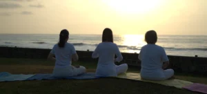 3 Students doing meditation during sunset