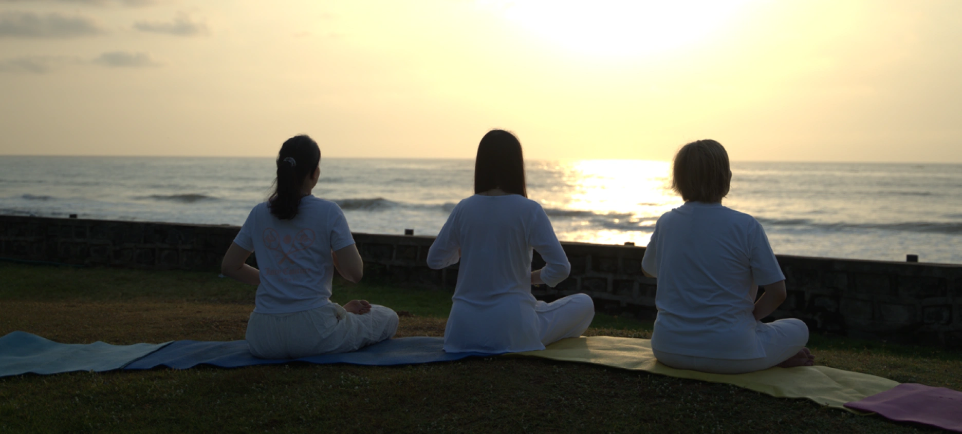 3 Students doing meditation during sunset