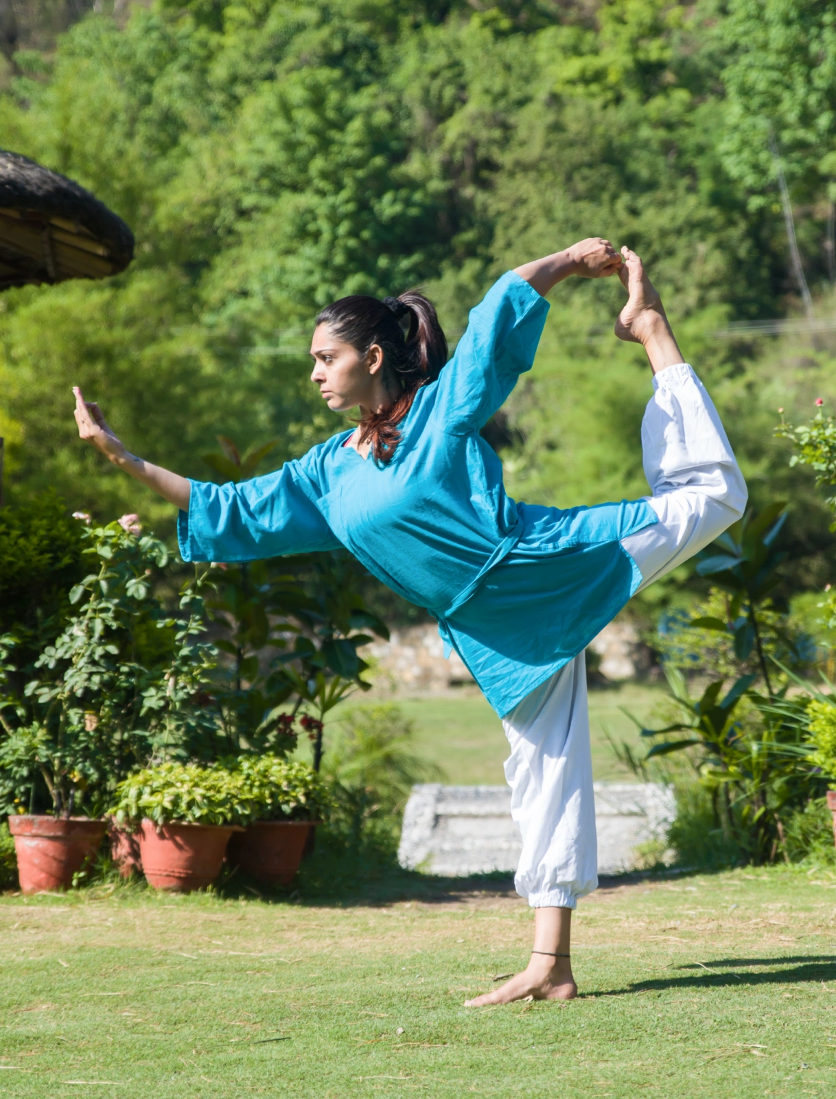 A girl performing yoga pose in green surrounding