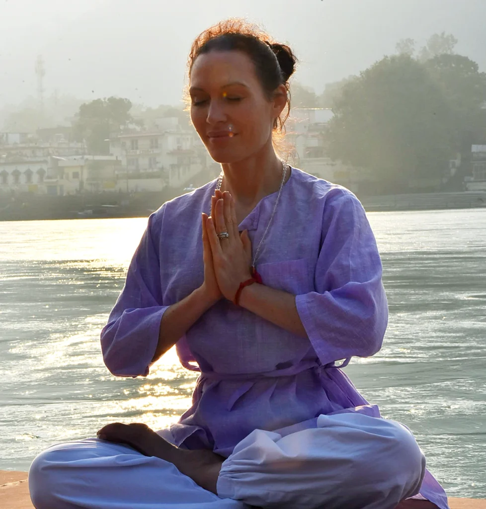 Yoga girl performing namaskar on the bank of Ganga river